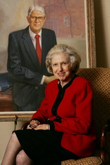 Ila Porter, broker and owner of Ben Porter Real Estate, sits in front of a portrait of her late husband, Ben Porter.